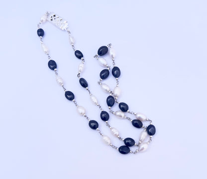 Close-up of polished Sapphire and Pearl gemstone beads showing glossy finish and elegant arrangement.