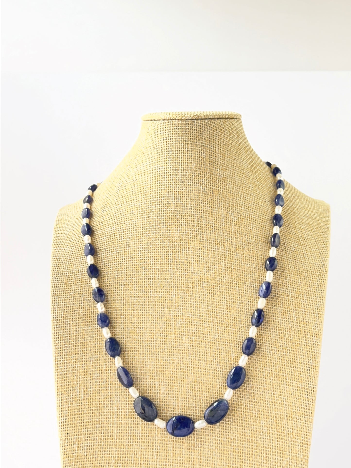 Single‑strand necklace featuring smooth oval blue sapphire and freshwater pearl beads sized 6.5–12.4mm.