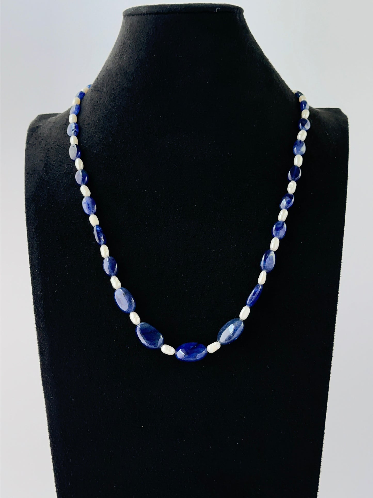 Blue sapphire and freshwater pearl necklace showcasing smooth oval beads in a single strand.