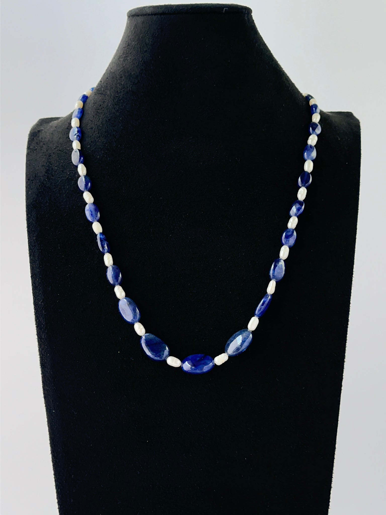 Blue sapphire and freshwater pearl necklace showcasing smooth oval beads in a single strand.