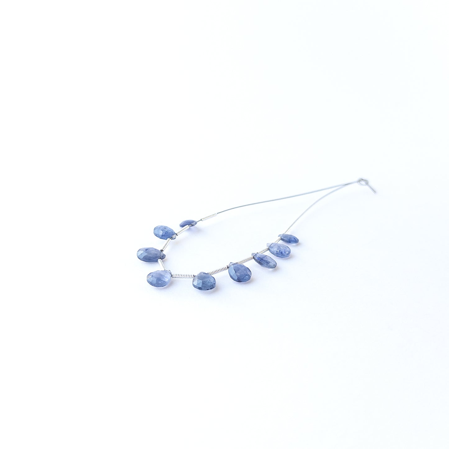 Close‑up of genuine Blue Sapphire faceted briolette beads showing sparkling facets and natural gemstone clarity.