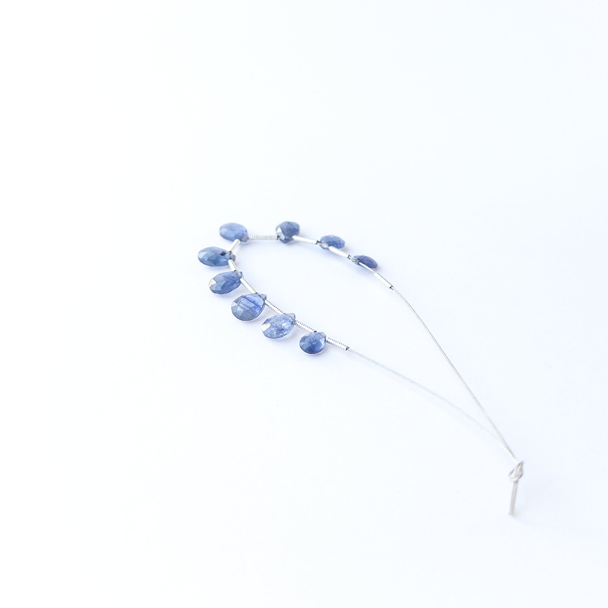 Blue Sapphire briolette beads showcasing natural shine and elegant teardrop faceting for gemstone creators.