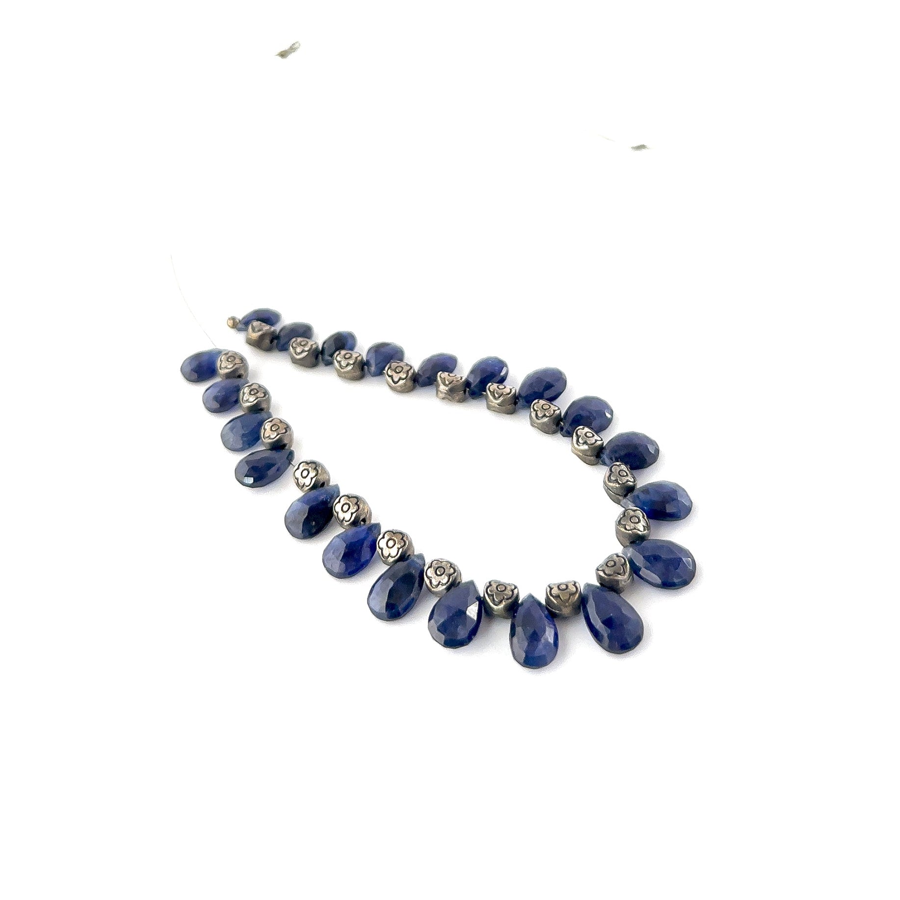 Close‑up of Blue Sapphire faceted briolette beads highlighting their reflective surfaces and intense blue tones.