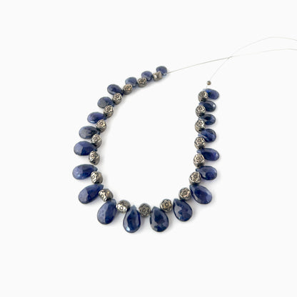 Blue Sapphire briolette beads featuring bright mirror‑like shine, rich blue saturation, and consistent shaping across 21 pieces.