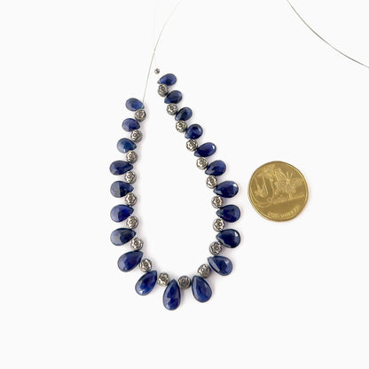 A coin is placed near Blue Sapphire briolette beads to show the 6–7.5mm size range.