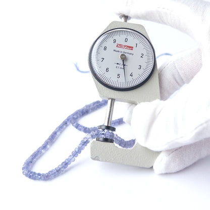 A dial gauge measures the Blue Sapphire faceted rondelle 3–4.2mm bead size gemstone.