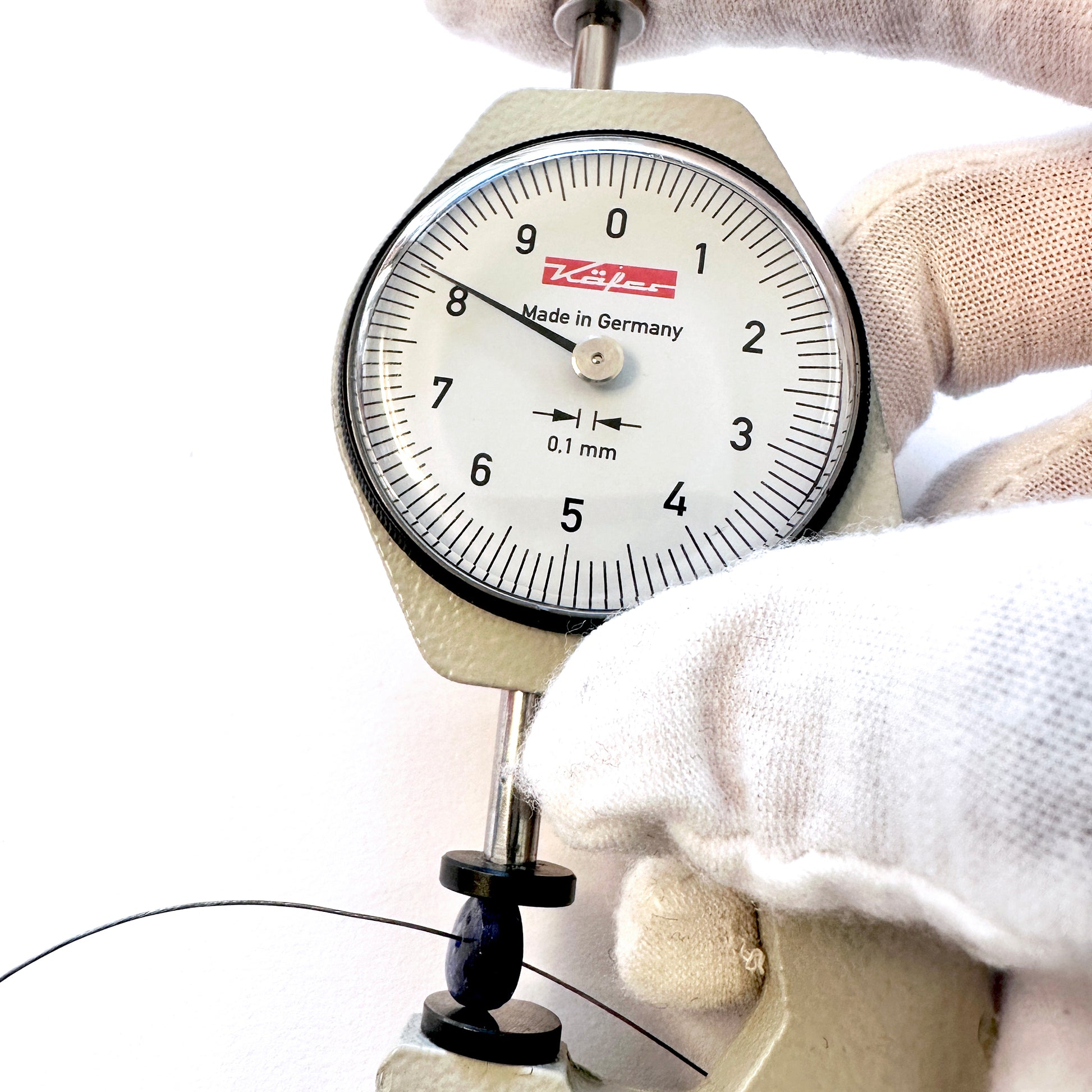 A dial gauge measures the Blue Sapphire Faceted Rondelle 8.1mm gemstone.