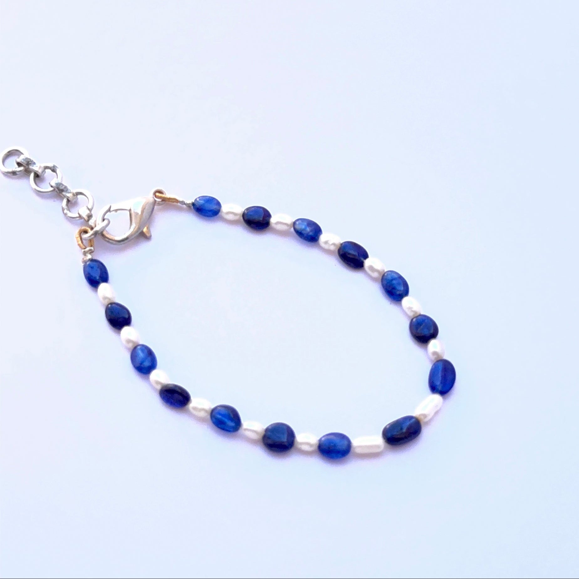 Elegant gemstone bracelet featuring blue sapphire and pearls in a refined layout.