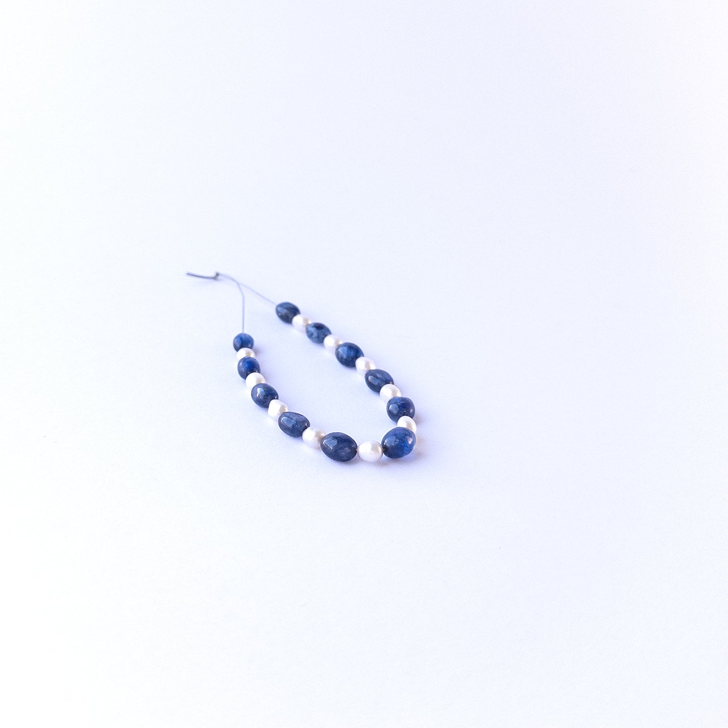 Strand of sapphire and freshwater pearl ovals displaying deep blue tones and soft pearl sheen for gemstone beads for DIY jewellery.