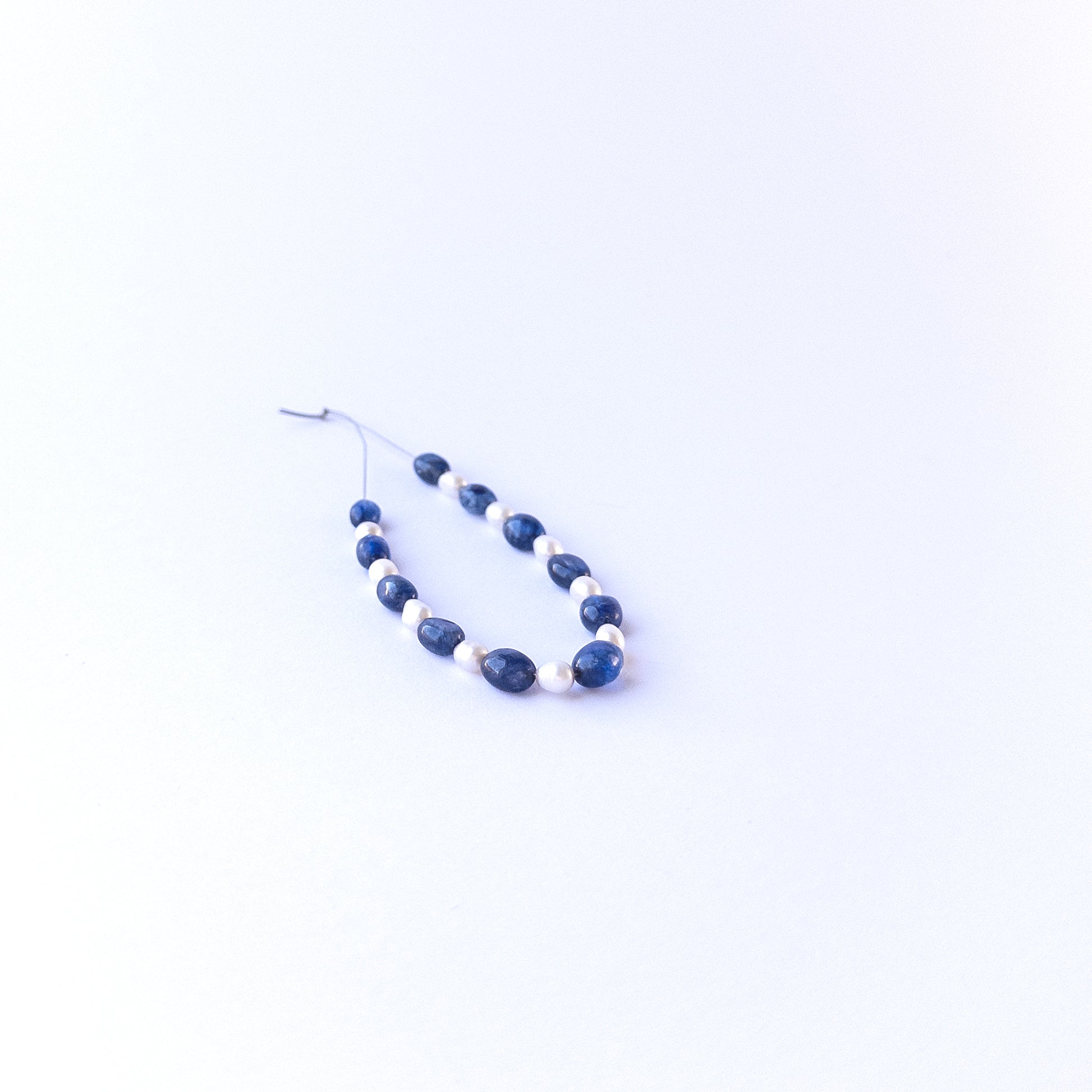 Strand of sapphire and freshwater pearl ovals displaying deep blue tones and soft pearl sheen for gemstone beads for DIY jewellery.