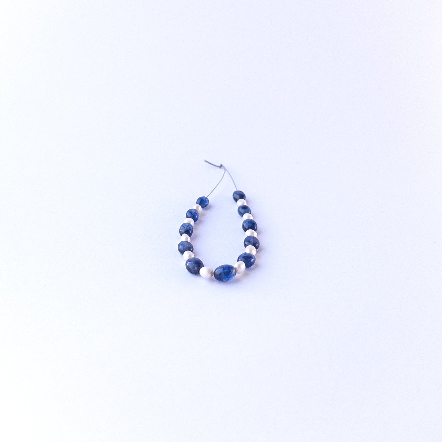 Detailed view of smooth oval sapphire and pearl beads with clean polish and elegant colour contrast for handmade jewellery components.