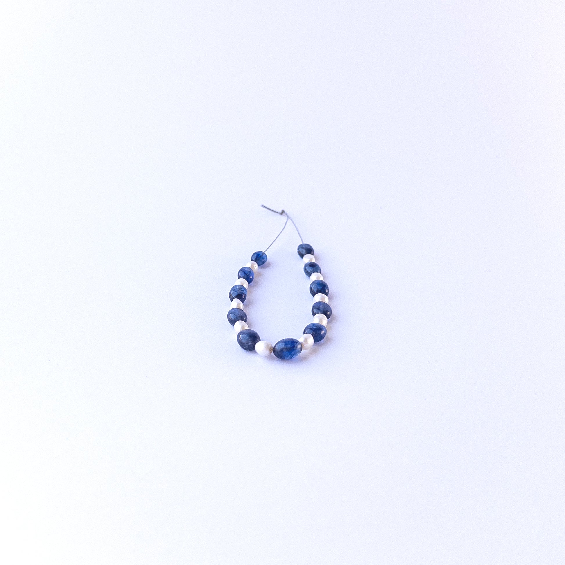 Detailed view of smooth oval sapphire and pearl beads with clean polish and elegant colour contrast for handmade jewellery components.