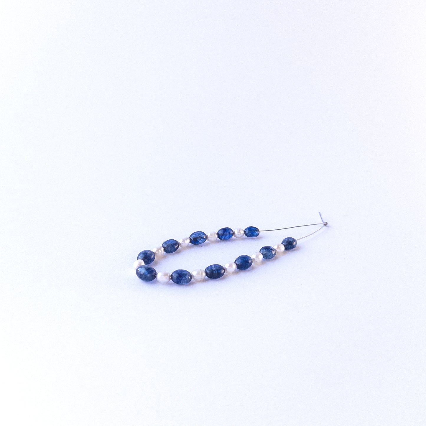 Mixed sapphire and freshwater pearl oval beads showing natural texture and quality for genuine gemstone bead crafting.