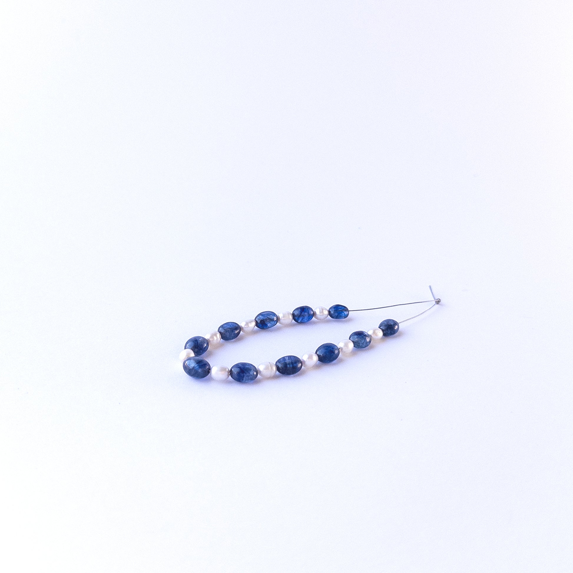 Mixed sapphire and freshwater pearl oval beads showing natural texture and quality for genuine gemstone bead crafting.