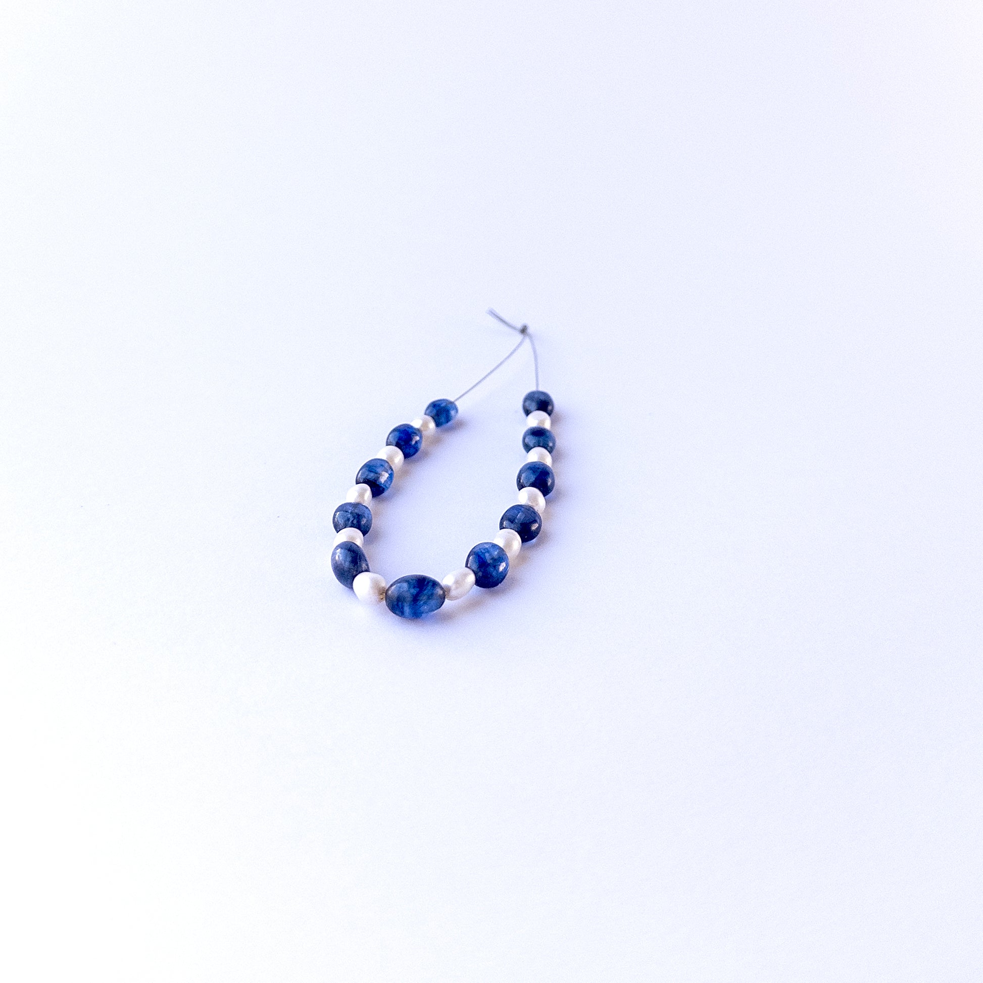 Authentic sapphire and pearl stone beads in smooth oval cuts showing polished finish for jewellery design work.