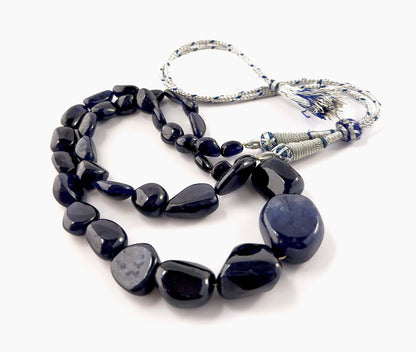 Close‑up of Blue Sapphire tumbled beads highlighting their polished surface, organic shapes and intense blue saturation.