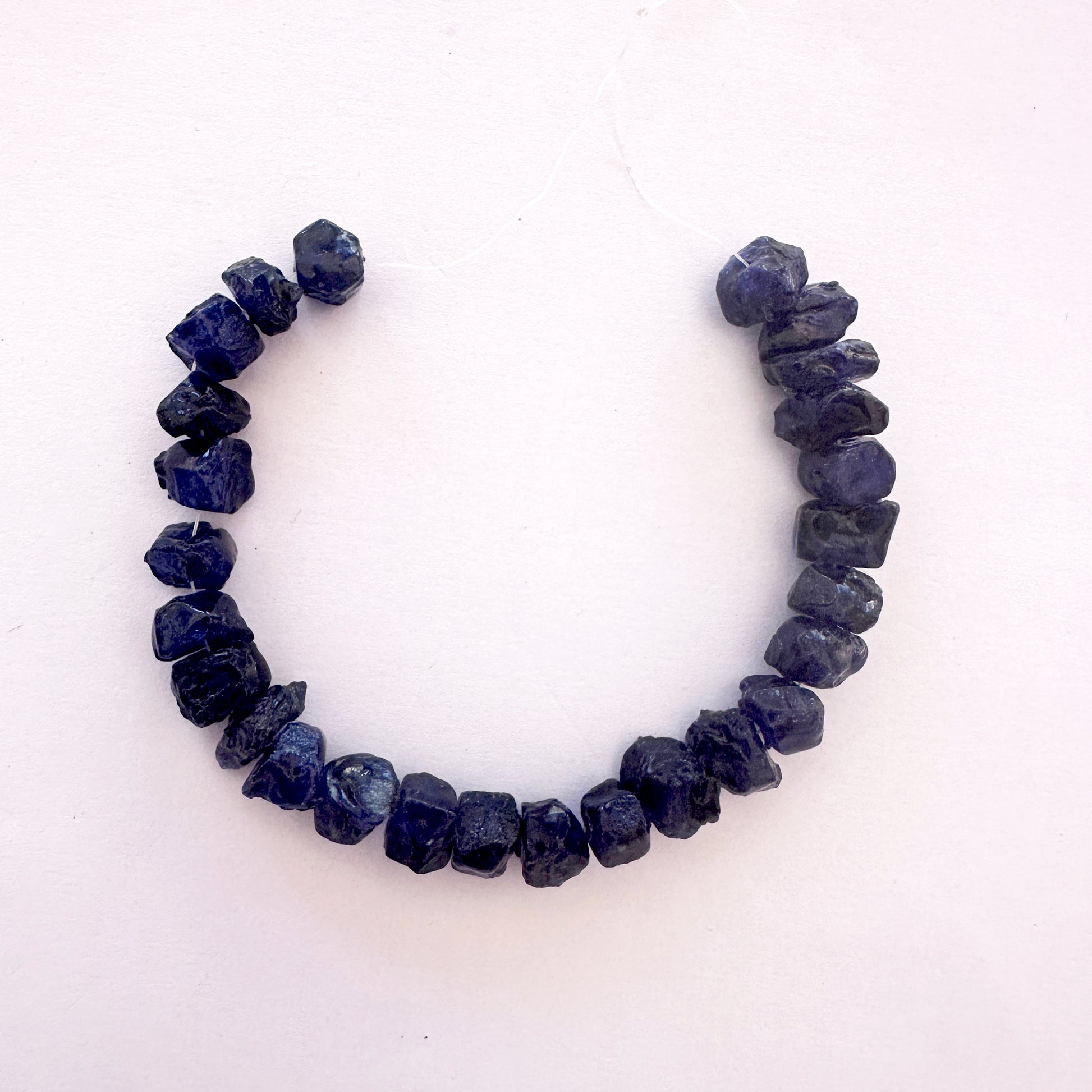 Blue sapphire rough beads with deep blue tones and centre-drilled 8.2–9.5mm size.