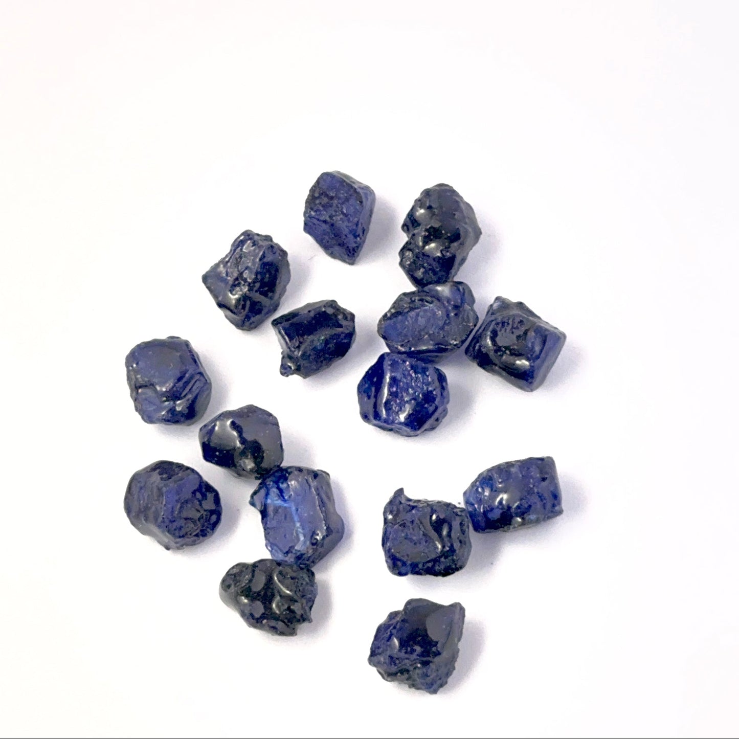 Close view of Blue Sapphire rough pieces arranged together, highlighting rich colour and handmade jewellery component quality.
