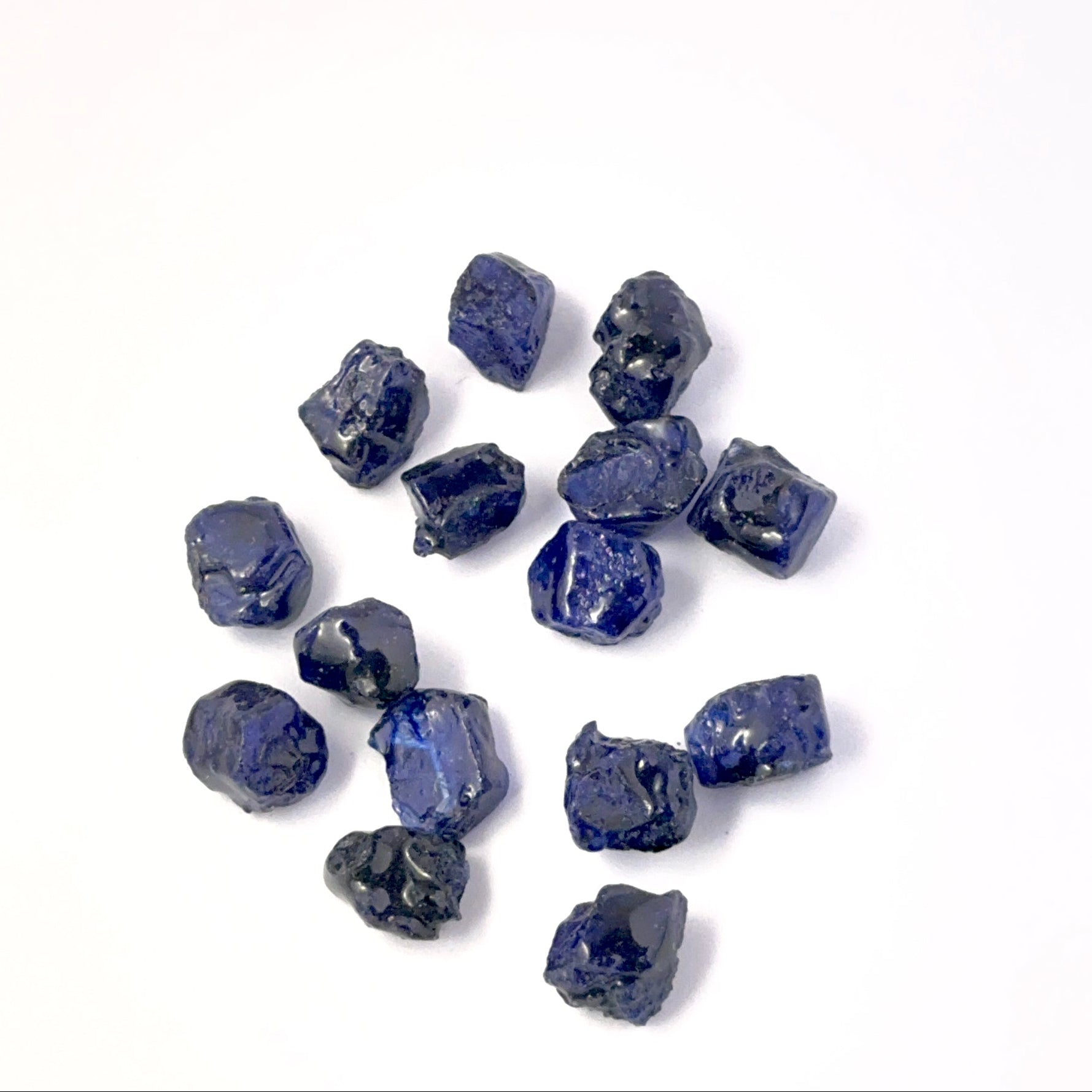 Close view of Blue Sapphire rough pieces arranged together, highlighting rich colour and handmade jewellery component quality.