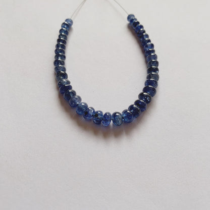 Natural Blue Sapphire beads in graduated sizes, highlighting their rounded cut and luminous blue hue.