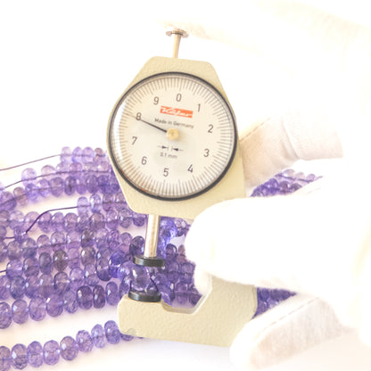 A dial gauge measures the Amethyst faceted rondelle 6.5–8.5mm gemstone.