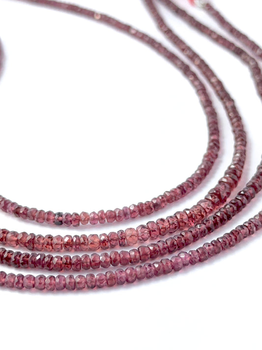 Faceted rondelle Burma Garnet stone beads arranged neatly, highlighting their polished finish and handmade jewellery component quality.