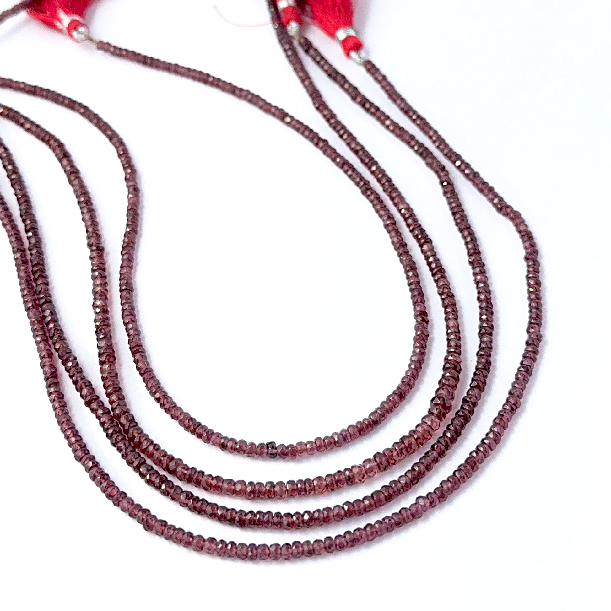 Delicate strands of Burma Garnet beads, showcasing their faceted rondelle design.