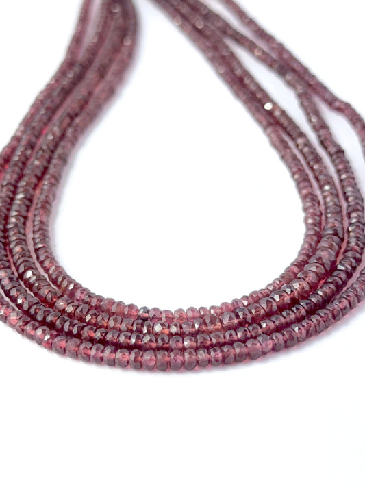Close view of Burma Garnet faceted rondelle stone beads showing cut, brilliance and smooth polish for DIY jewellery makers.