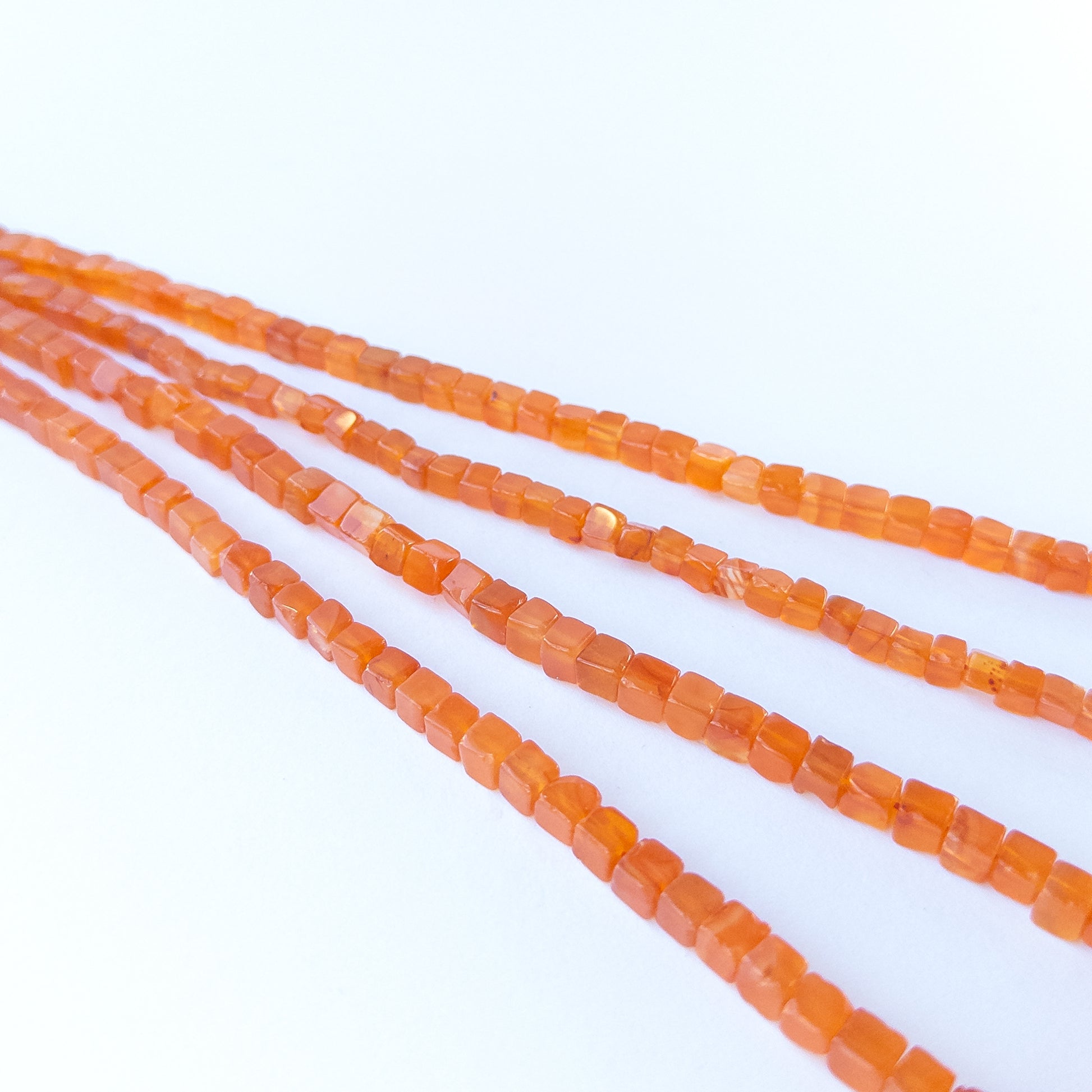 Authentic Carnelian gemstone beads showcasing polished cube cuts ideal for handmade jewellery components.