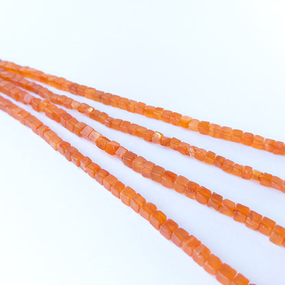 Authentic Carnelian gemstone beads showcasing polished cube cuts ideal for handmade jewellery components.