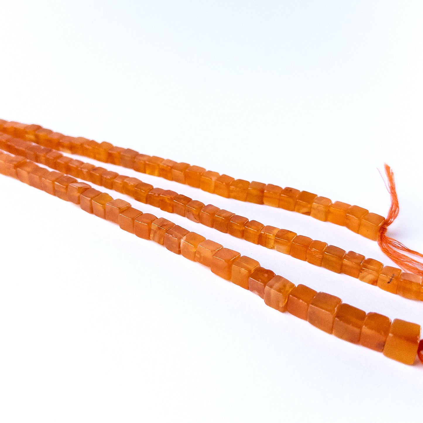 High quality Carnelian gemstone beads arranged on a strand, perfect for artisan beadwork.