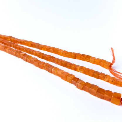 High quality Carnelian gemstone beads arranged on a strand, perfect for artisan beadwork.