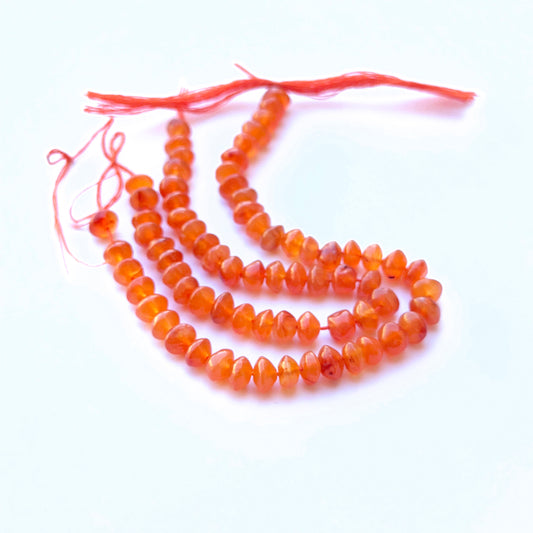 Close‑up of 5.5–6mm Carnelian stone beads showing polished surfaces and rich colour ideal for natural gemstone beads for DIY jewellery.