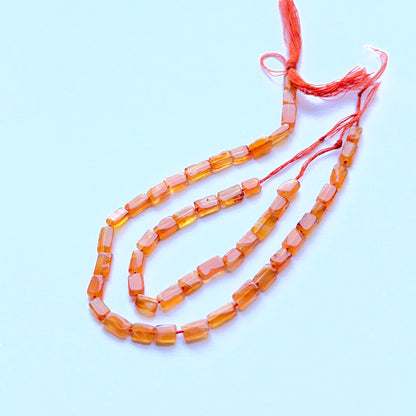 Carnelian smooth rectangle beads aligned on a strand highlighting clarity, shine and consistent sizing.