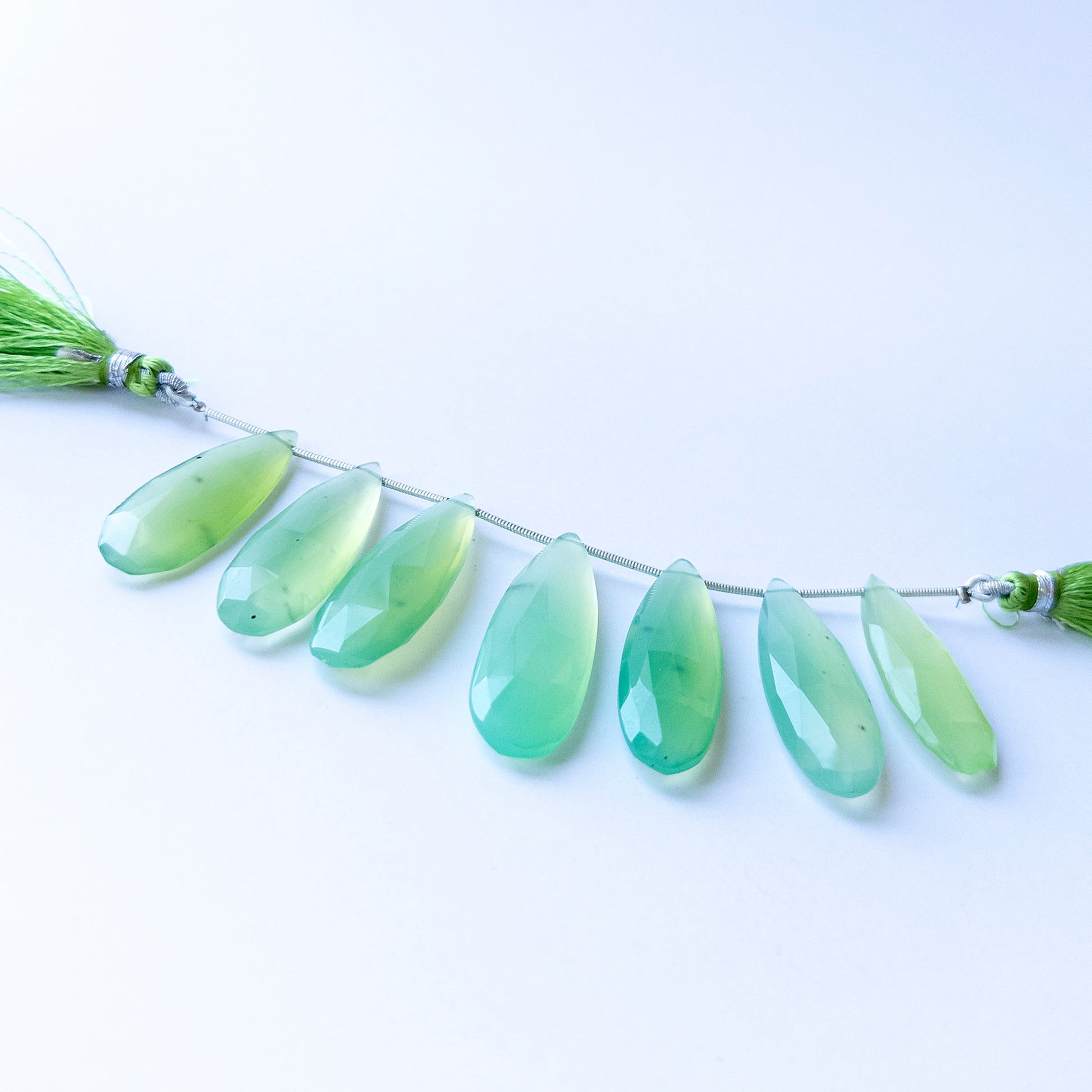 Genuine Chalcedony gemstone beads displaying soft blue tones, polished facets, and beautifully elongated shapes for jewellery design.