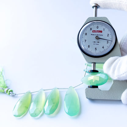 A dial gauge measures the Chalcedony faceted briolette 28–39mm gemstone.