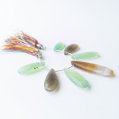 Handmade jewellery components featuring large faceted Chalcedony briolette beads in a neatly arranged set.