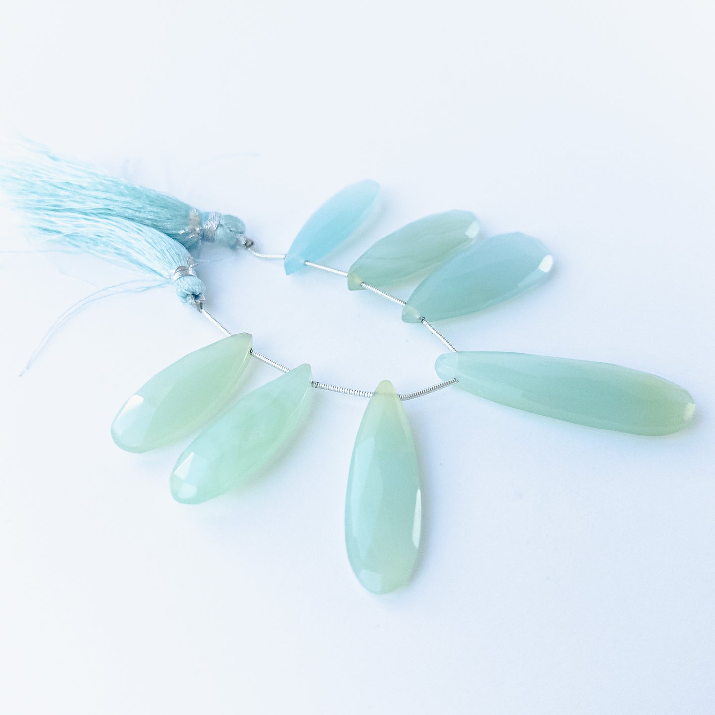 Chalcedony faceted briolette beads 29–45mm × 12–15mm shown as a set of six polished teardrop gemstones.