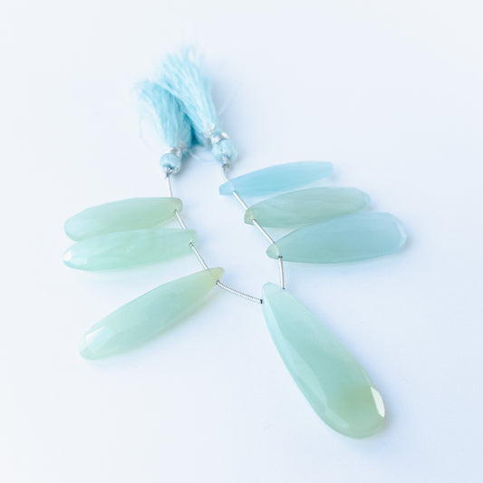 Natural Chalcedony faceted briolette stones displaying soft pastel tones and elongated teardrop shapes.