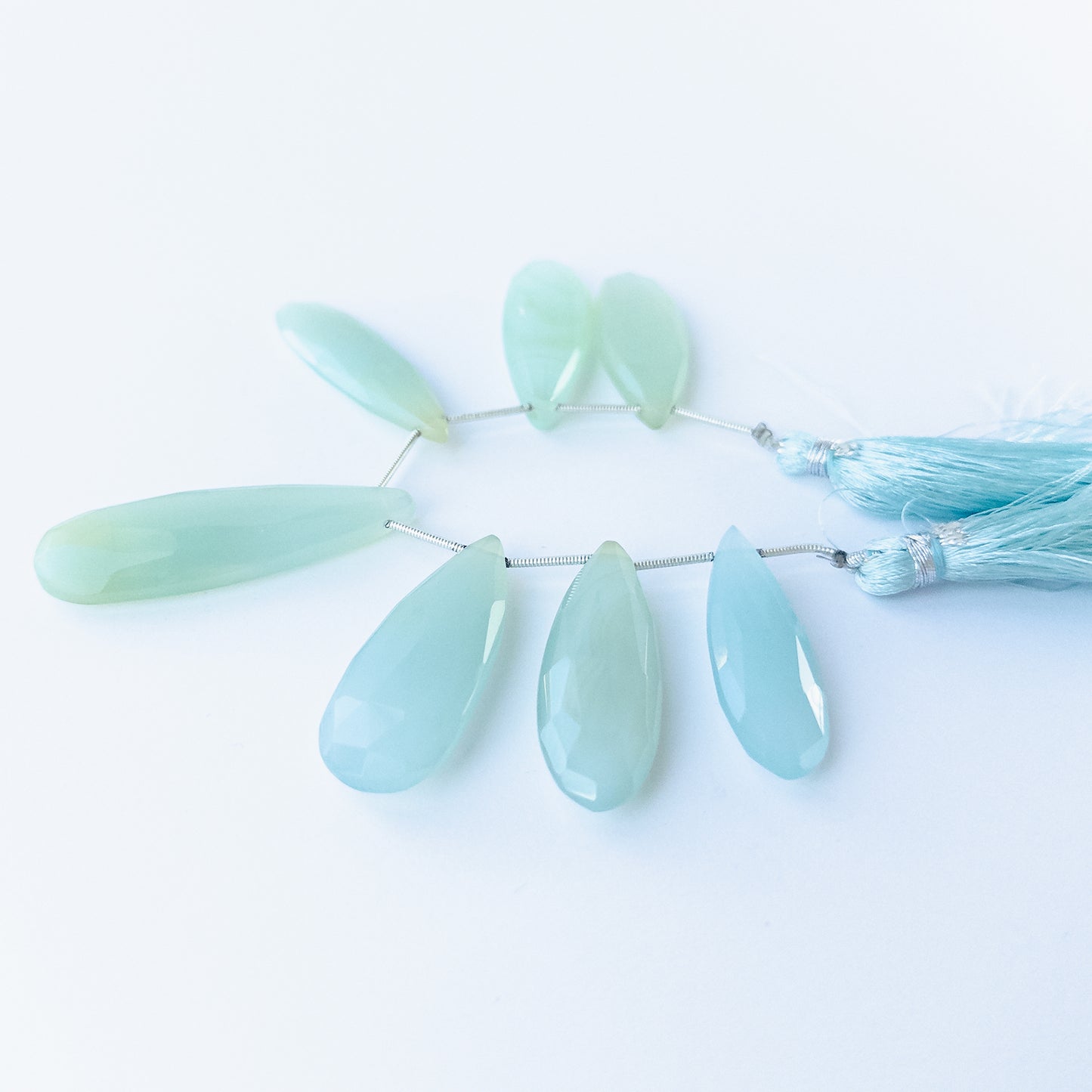 Close‑up of Chalcedony faceted briolette beads highlighting their sparkle, clarity and carved teardrop form.