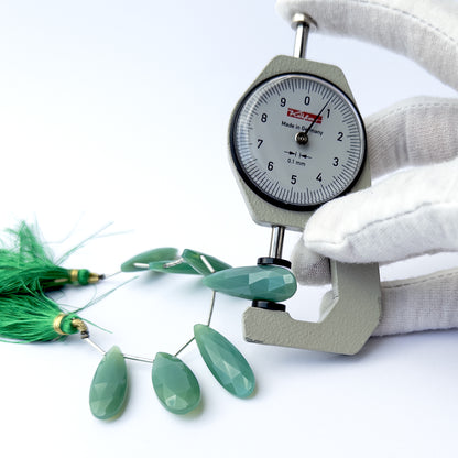 A dial gauge measures the Chalcedony faceted briolette 29–34mm gemstone.