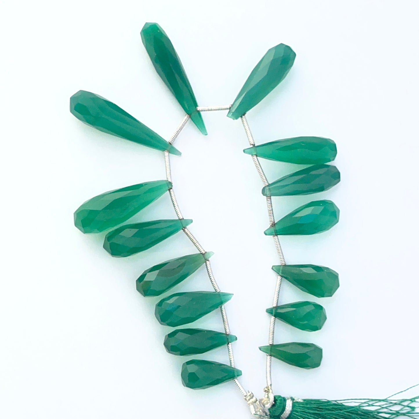 Green Chalcedony faceted briolette teardrop beads showing bright translucent colour and polished cuts.