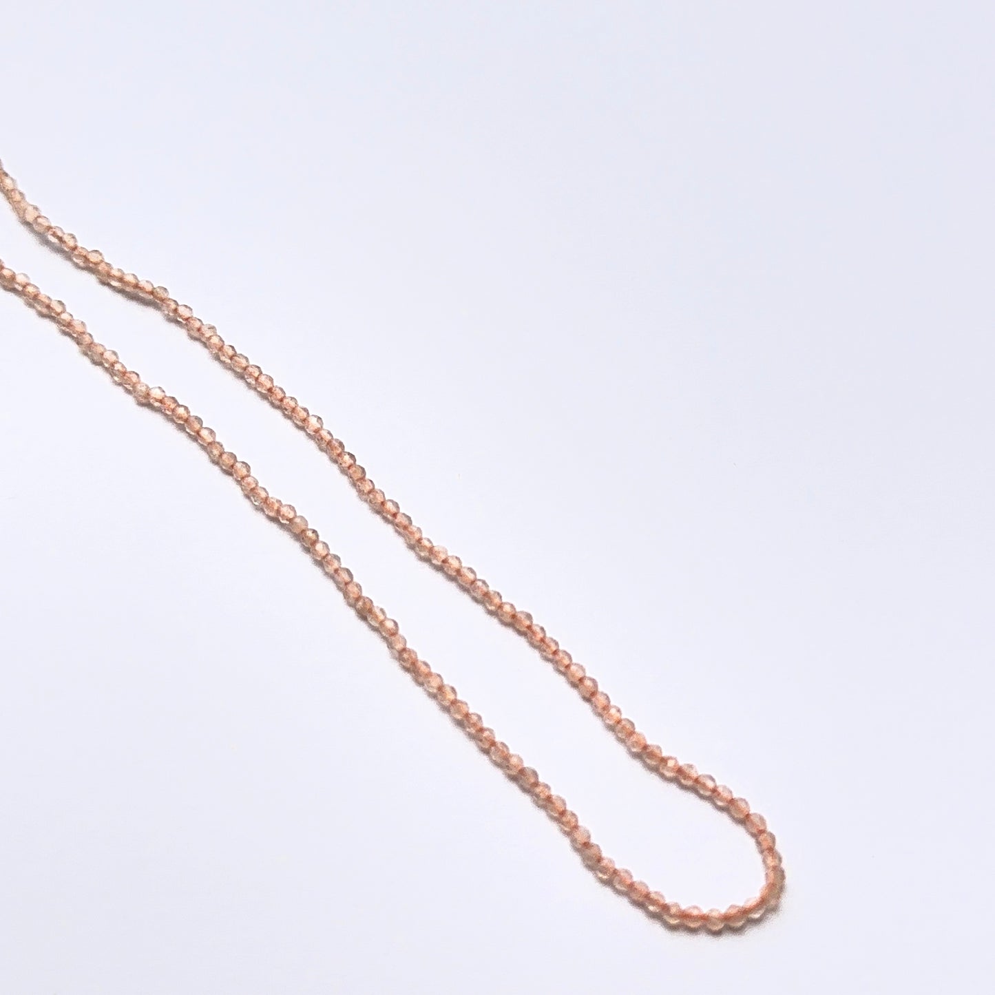 Chalcedony 1.9mm faceted rondelle beads arranged on a strand, showing crisp faceting and pale blue tones.