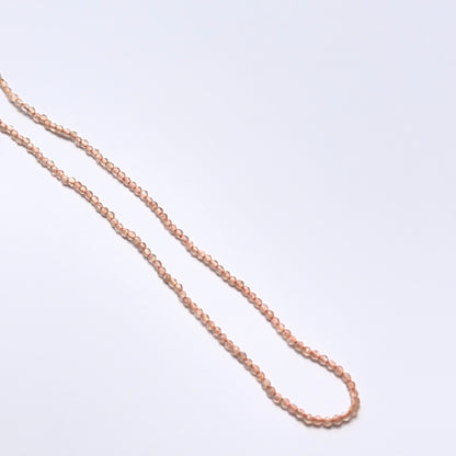 Chalcedony 1.9mm faceted rondelle beads arranged on a strand, showing crisp faceting and pale blue tones.