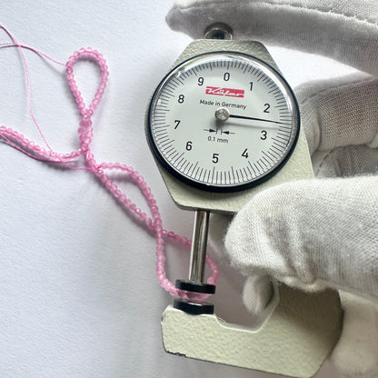A dial gauge measures the Chalcedony faceted rondelle 2.6mm gemstone.