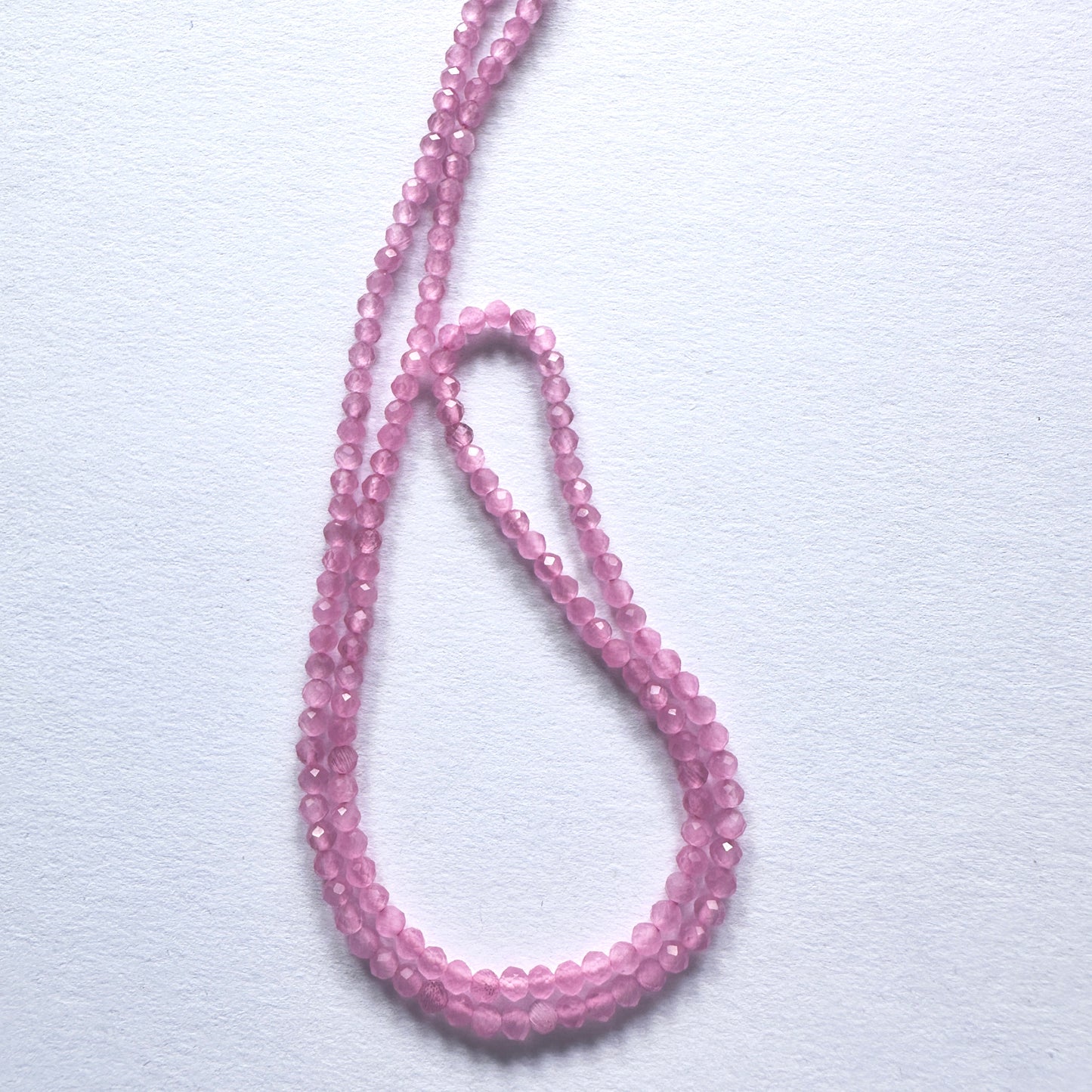 Close-up of Chalcedony beads showcasing their refined cut and gentle colour.
