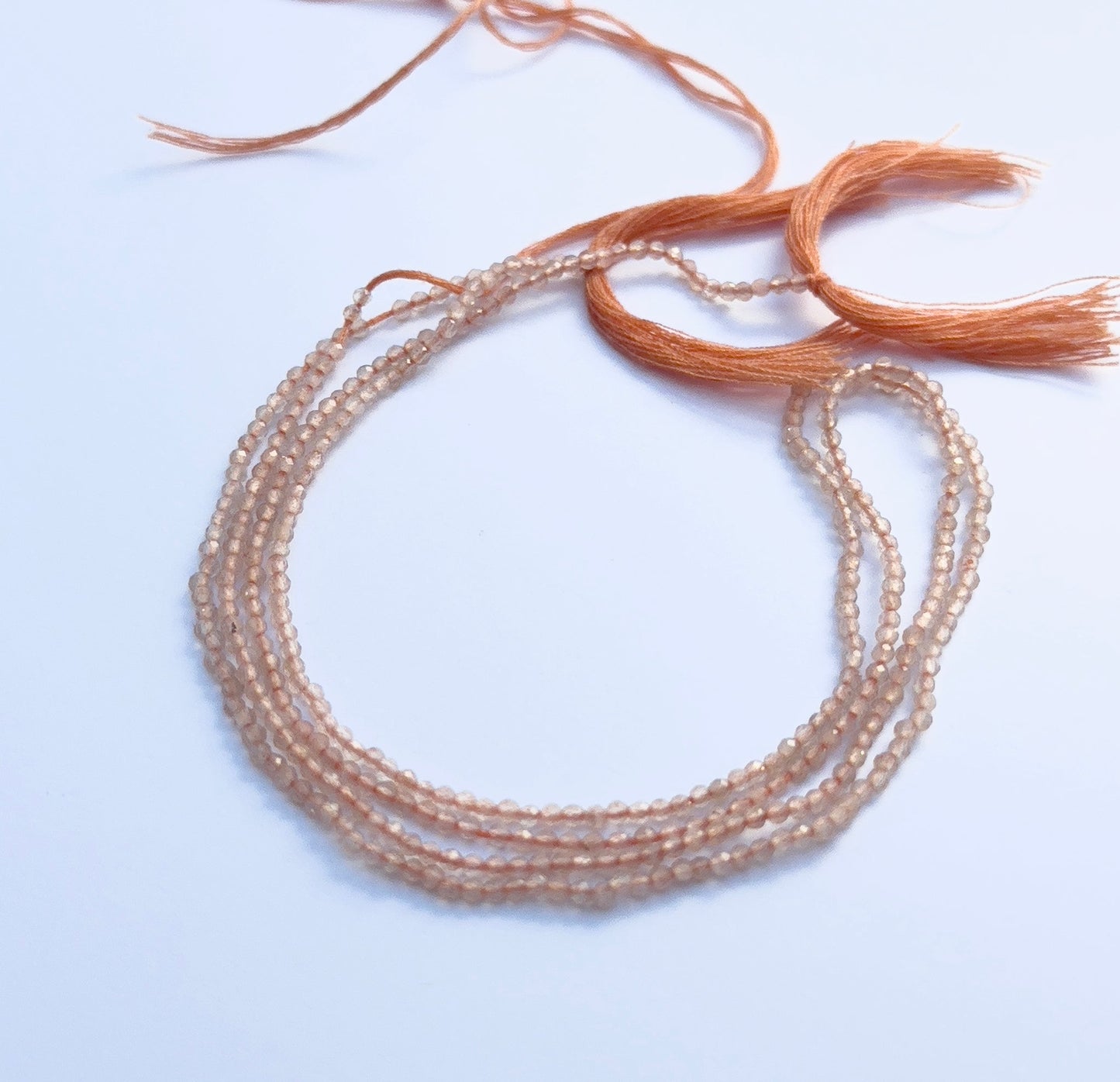 Natural chalcedony gemstone beads in faceted rondelle cut, 2mm size, arranged on a 32cm strand.