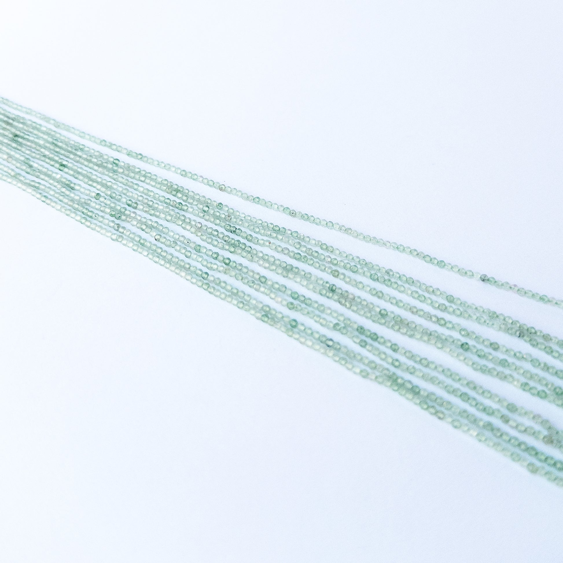 Handmade jewellery components featuring natural chalcedony faceted rondelle beads in a neatly aligned strand.
