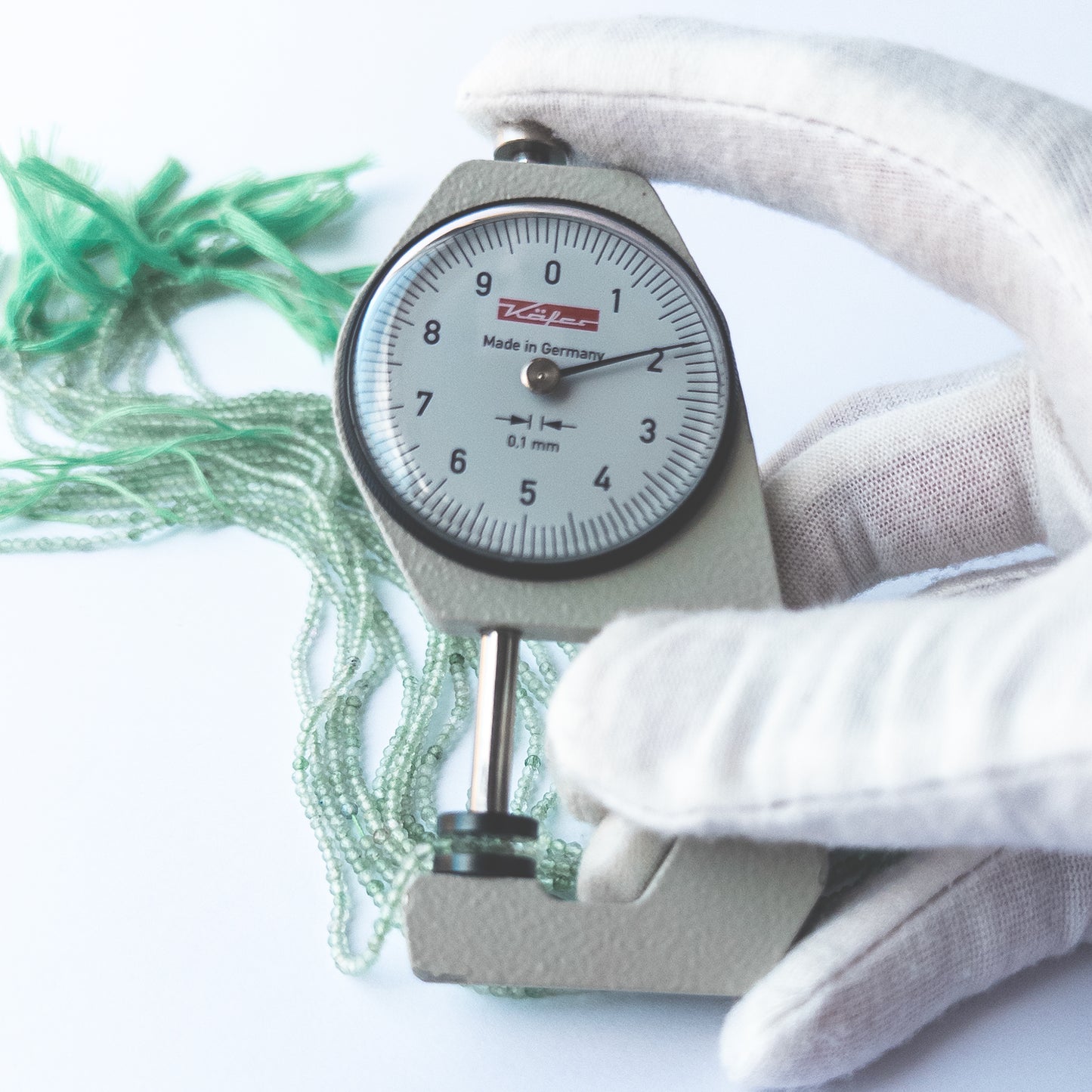 A dial gauge measures the Chalcedony faceted rondelle 2mm gemstone.