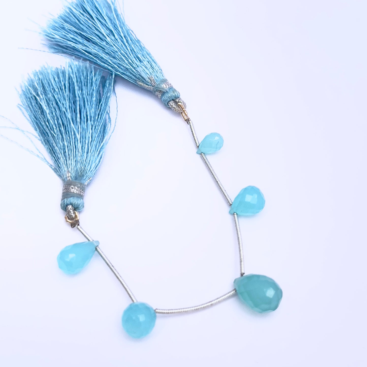 Stone beads in Chalcedony finish laid flat to highlight their 8.6×5.5mm to 12.8×9.1mm size and faceting.